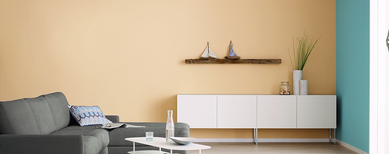 Wohnzimmer mit weißen und braunen Möbeln mit orange beiger Wand und blauen Akzenten.